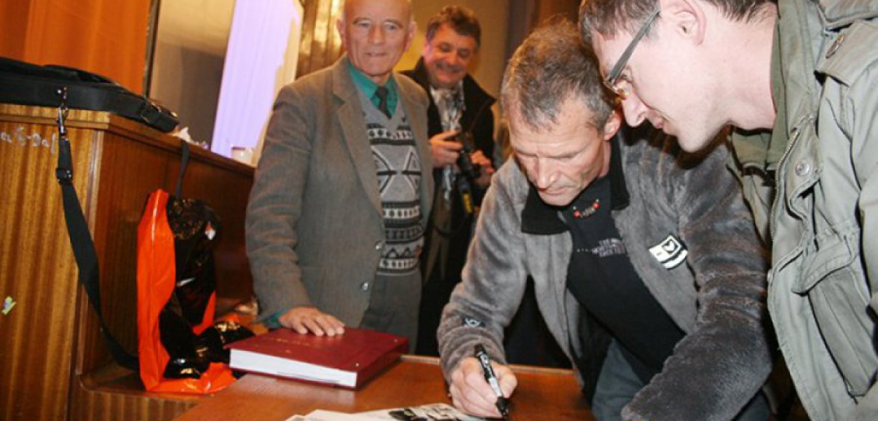 Ryszard Pawłowski podpisuje na kalendarzu dedykację dla podopiecznych Specjalnego Ośrodka Szkolno-Wychowawczego w Chrzanowie