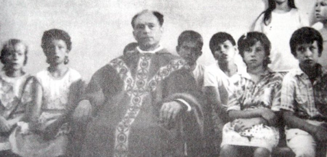 Ks. Adolf Chojnacki z dziećmi ze Stalowej Woli na IV Obozie Młodzieży Niezależnej w Juszczynie. (Zdjęcie pochodzi z książki Jana Żaryna &#8222;Kościół w PRL&#8221;). 