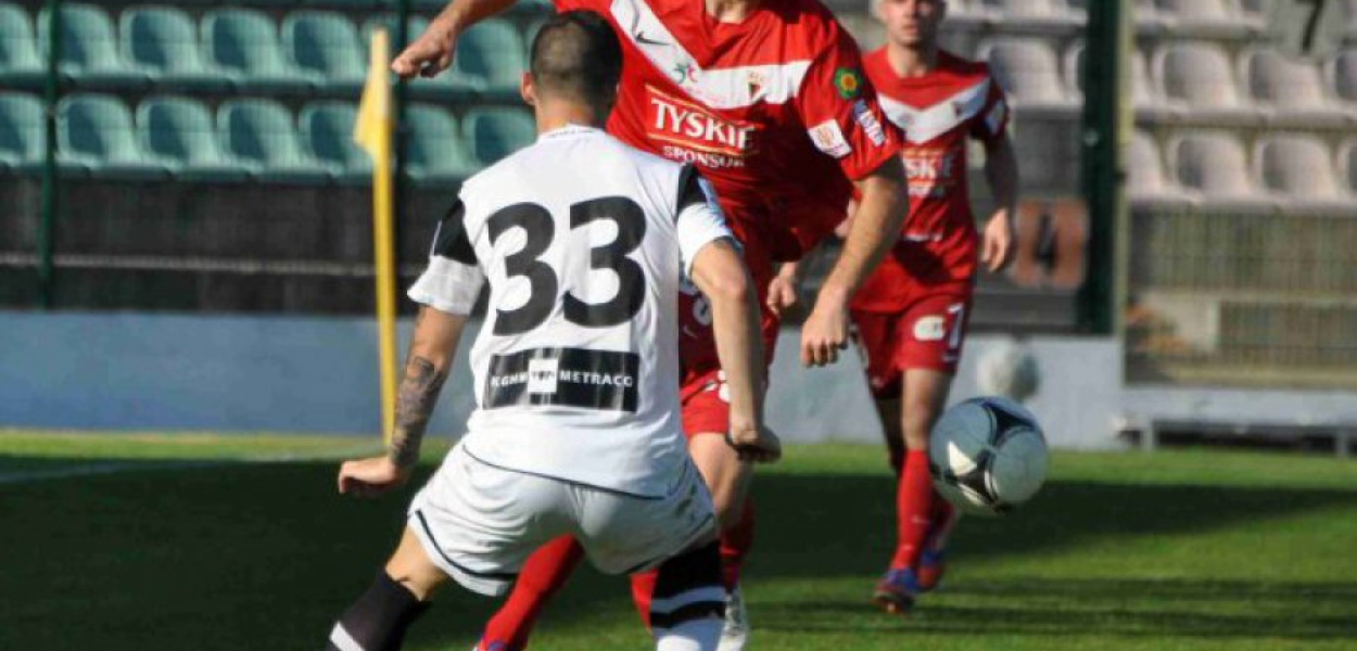 Napastnika GKS Tychy Pawła Smółkę próbuje powstrzymać defensor Zagłębia Lubin Lubomir Guldan (numer 33)