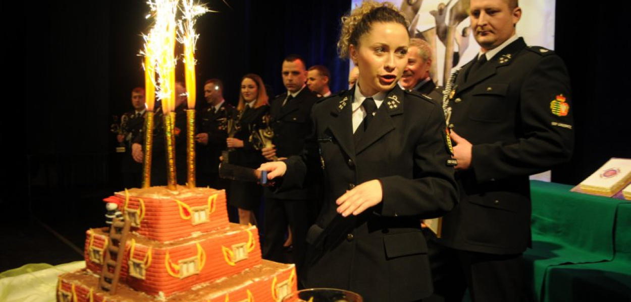 Jagoda Jankowska, prezes OSP Chrzanów, kroi tort upieczony specjalnie dla zwycięzcy plebiscytu