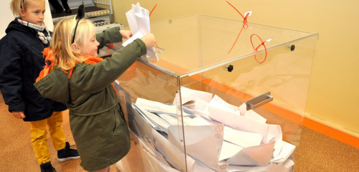 Dzieci wrzucają do urn karty wypełnione przez rodziców
