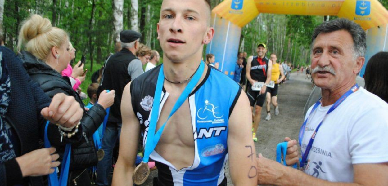 Koordynator triathlonu Tadeusz Adamczak wręczył na mecie imprezy z 2017 roku medal Karolowi Kulawikowi z Trzebini