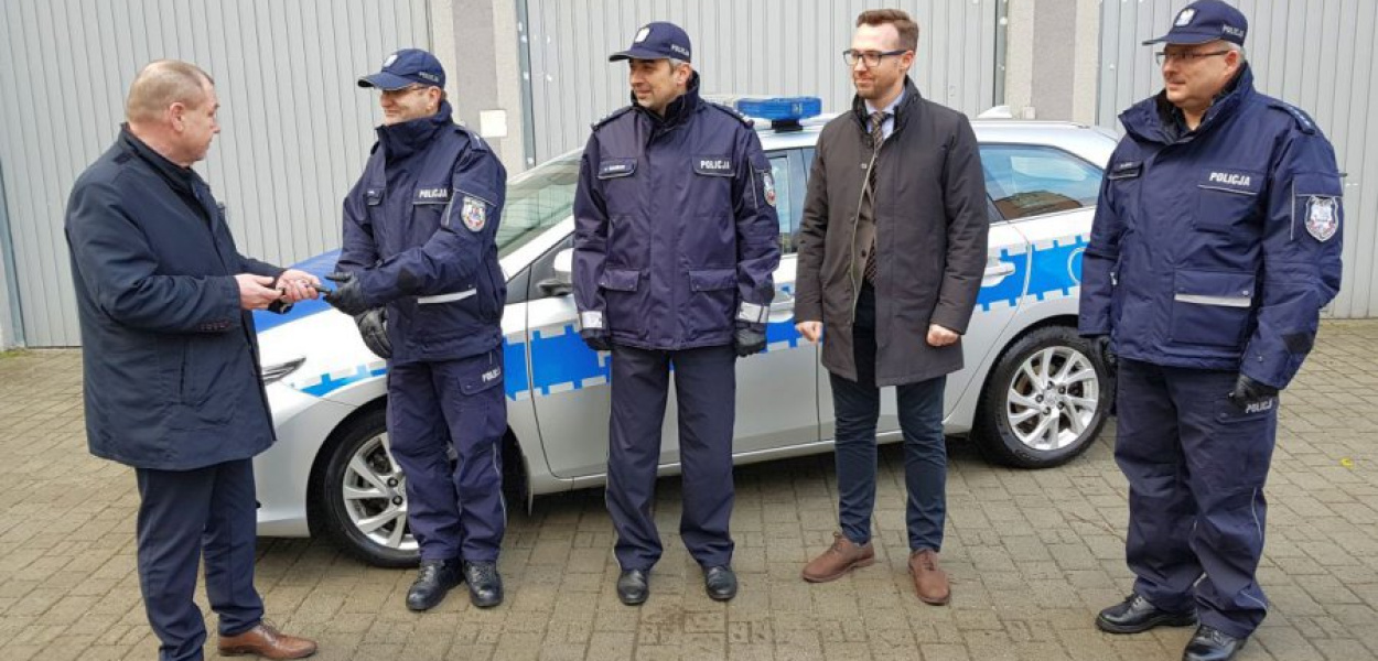 Starosta Andrzej Uryga przekazuje kluczyki do nowego pojazdu na tle oznakowanego radiowozu. Tego nowego pojazdu nie możemy pokazać. 