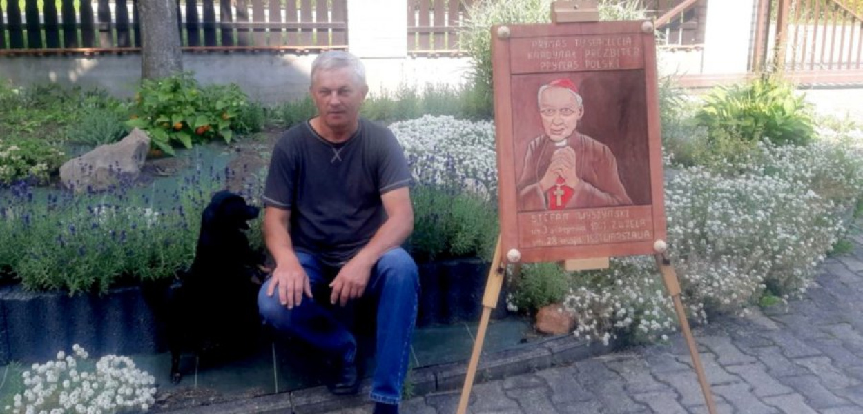 Edward Fiba przy drewnianym obrazie kardynała Stefana Wyszyńskiego na swoim ogródku. FOT. z archiwum rodziny
