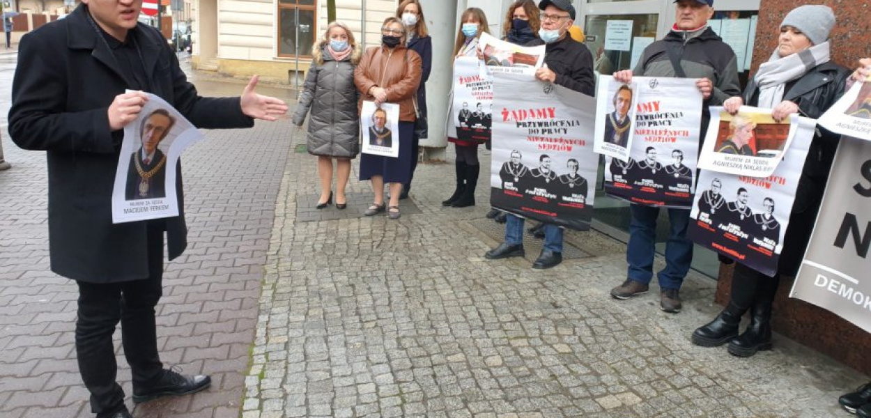 Sędzia Jakub Krawiec rozmawia ze zgromadzonymi przed sądem uczestnikami spotkania