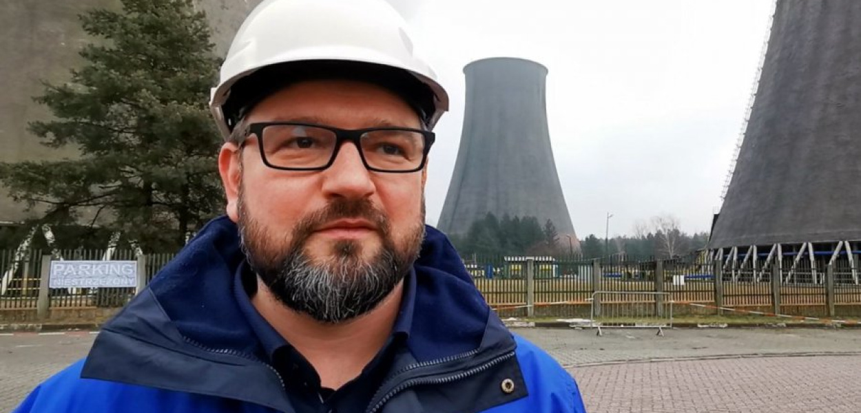 Maciej Stecki na tle chłodni kominowych w trzebińskiej elektrowni