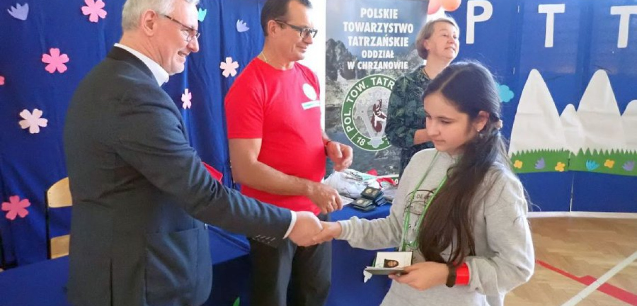 Jedna z uczennic odbiera legitymację członkowską PTT, fot. Andrzej Marcinek