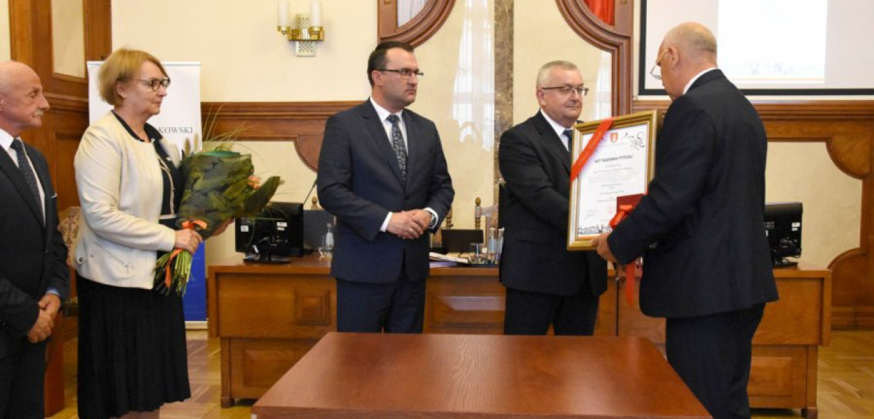 Minister Andrzej Adamczyk otrzymuje tytuł &quot;Zasłużony dla powiatu krakowskiego&quot;. Akt nadania wręcza przewodniczący rady Piotr Goraj. Od lewej stoją: wiceprzewodniczący rady Marek Piekara, wiceprzewodnicząca rady Alicja Wójcik i starosta krakowski Wojciech Pałka. FOT. Krzysztof Kamiński