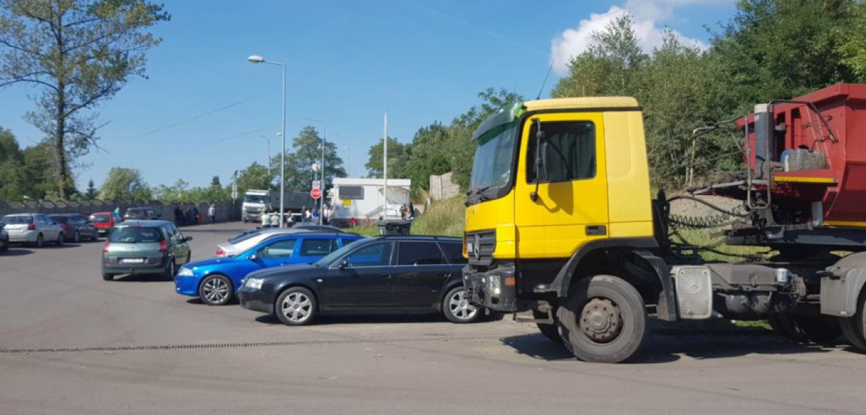 Pod punktem sprzedaży węgla stoi wiele samochodów na rejestracjach z całego kraju, w których koczują ludzie