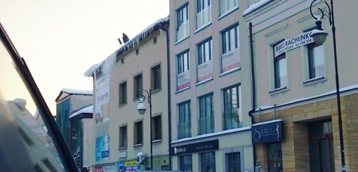 Usuwanie śniegu z dachu budynku przy Garncarskiej w Chrzanowie