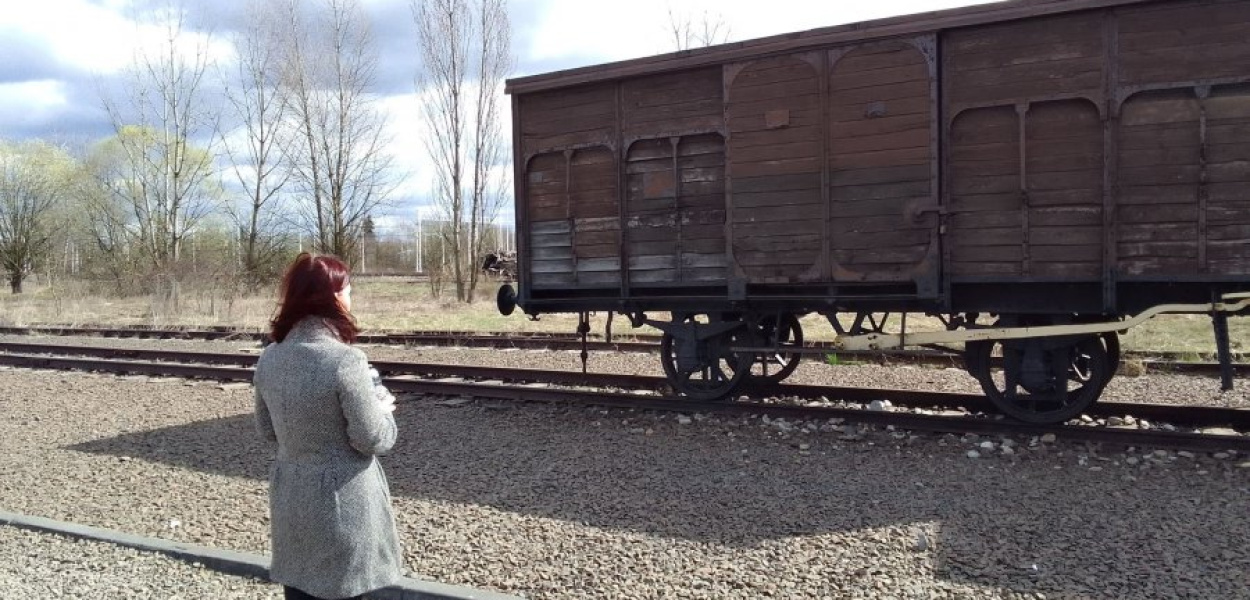 Agnieszka Molenda-Kopijasz Prezes Fundacji Pobliskie Miejsca Pamięci Auschwitz-Birkenau przed wagonem bydlęcym na Judenrampe Birkenau.