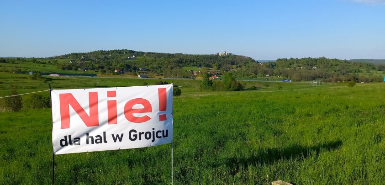 Na działkach za tym banerem miałyby powstać hale centrum logistycznego