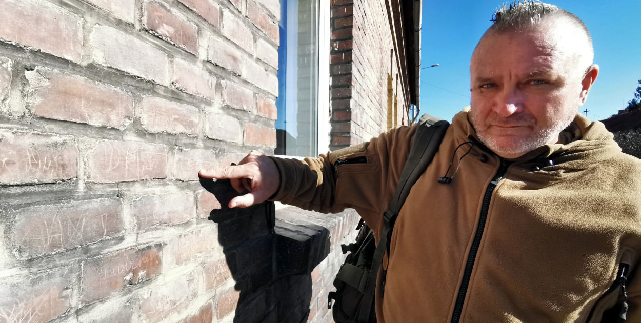 Mirosław Dudek pokazuje napisy na zewnętrznej ścianie domu przy ul. Krakowskiej w Babicach. Na cegłach wyryte zostały imiona i nazwiska żołnierzy Armii Czerwonej, którzy dotarli tu podczas drugiej wojny światowej.