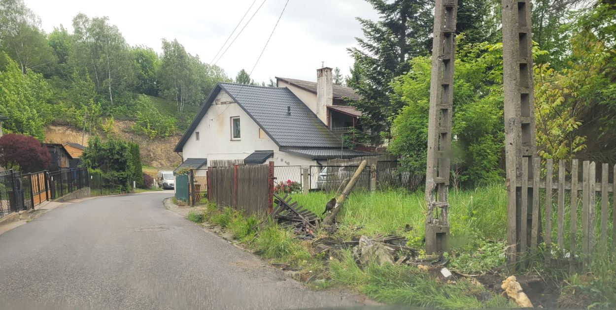 Trzebinia, Styczniowa. Najnowszy wyczyn drogowego pirata - uszkodzone ogrodzenie i zwalony drewniany słup. Betonowy energetyczny cudem ocalał.
