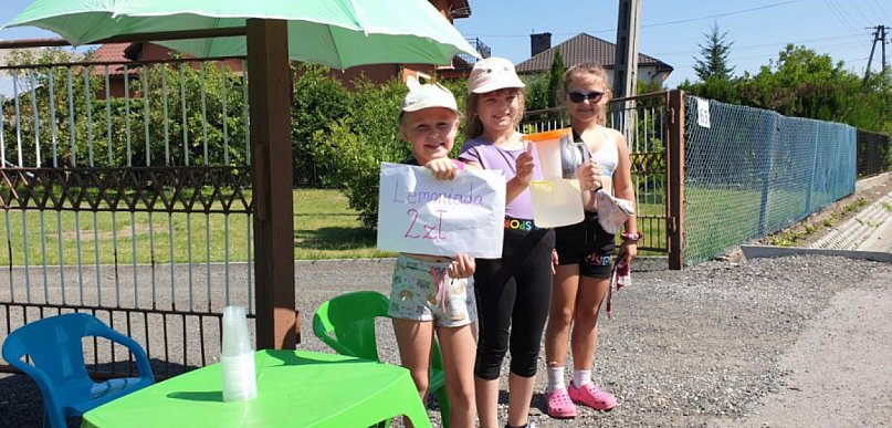 Sposób na wakacyjną nudę. Dziewczynki sprzedają przy drodze lemoniadę